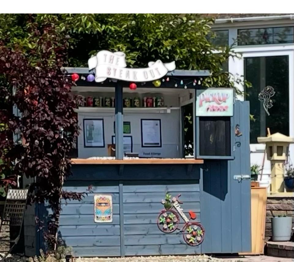 The blue-grey Steak Out garden kiosk